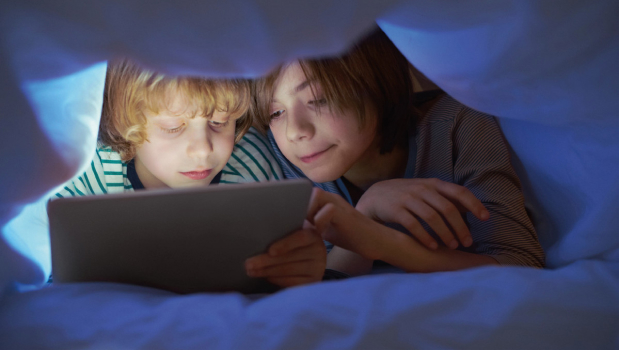 Kids under blanket with tablet